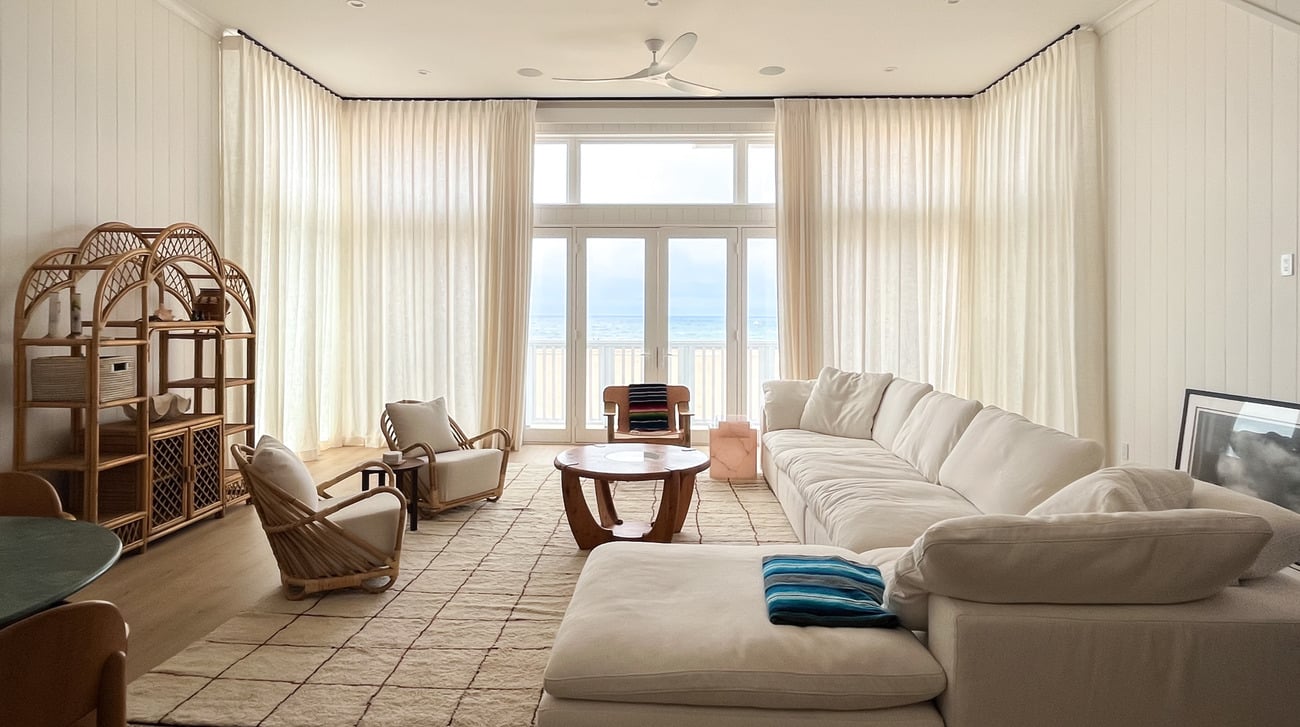 Living room with draped windows and beachfront view